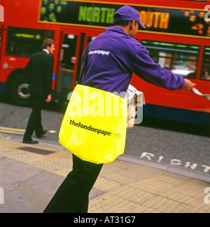 Un homme distribue les papiers dans les rues de Londres London UK Banque D'Images