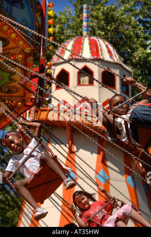 Les ENFANTS DANS UNE CIRCONSCRIPTION SIÈGES SUSPENDUS merry go round À L'INNOCENT FÊTE DU VILLAGE À REGENTS PARK LONDRES 2007 Banque D'Images