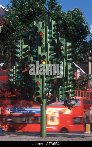 Feu de circulation tree sculpture (Pierre Vivant, 1998), au centre du rond-point avec red doubledecker bus derrière, London Docklands Banque D'Images