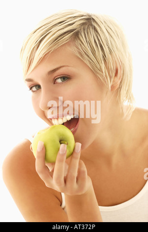 Une femme prenant une bouchée d'une pomme Banque D'Images