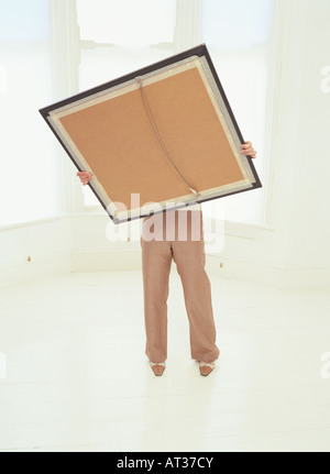 Une femme tenant un grand photo frame Banque D'Images