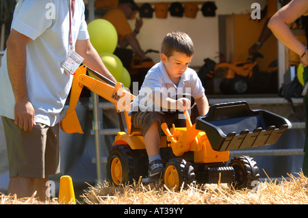 Un père AIDE SON ENFANT JOUER SUR UN JOUET DIGGER À L'INNOCENT FÊTE DU VILLAGE À REGENTS PARK LONDRES 2007 Banque D'Images