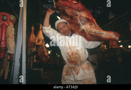 Boucher avec le boeuf jambe à Smithfield meat market, Londres Banque D'Images