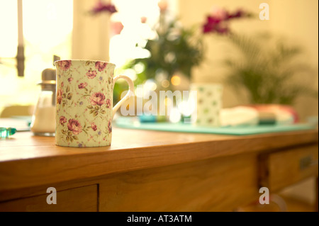 Une tasse avec un motif fleuri sur une table Banque D'Images