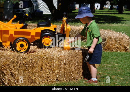 Un ENFANT QUI JOUE AVEC UN JOUET DIGGER À L'INNOCENT FÊTE DU VILLAGE À REGENTS PARK LONDRES 2007 Banque D'Images