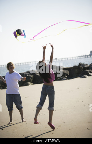 Un jeune couple sitting on a beach Banque D'Images