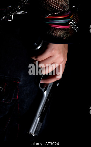 Young Girl holding handgun vers le bas à ses côtés Banque D'Images