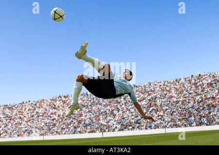 Joueur de football faisant scissor kick Banque D'Images