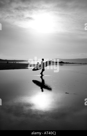 Silhouette d'un surfeur allant à la mer. Banque D'Images