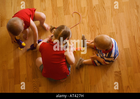 Enfants jouant ensemble sur le plancher Banque D'Images