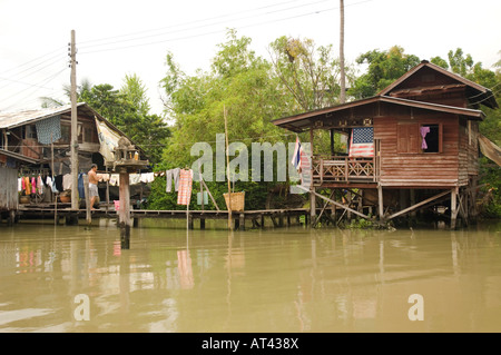 Un homme est d'accrocher les vêtements pour les faire sécher dans un quartier construit sur un canal dans le centre de Bangkok en Thaïlande Banque D'Images