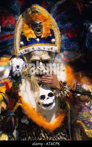 Portrait d'un chaman tobas / danseur sorcier portant des crânes en plastique et coiffe, festival CH'utillos, Potosi, Bolivie Banque D'Images