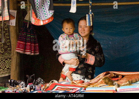 Femme et enfant vente de batiks tissus de chanvre dans le Baan Pha nok kok village Hmong, parc national de Doi Inthanon Thaïlande Banque D'Images