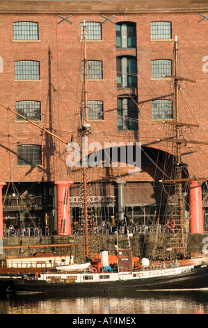 Albert Dock Liverpool - bateau amarré dans le dock par l'un des entrepôts convertis maintenant appartements bars et restaurants Banque D'Images