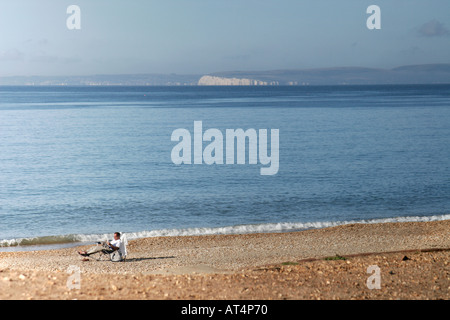 La lecture de l'homme dans la chaise longue sur la plage à Hengistbury Head BOURNEMOUTH Dorset England UK Banque D'Images