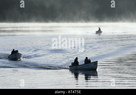 Les pêcheurs de partir dans des bateaux sur un matin brumeux, Pitsford Reservoir, Northamptonshire, England, UK Banque D'Images