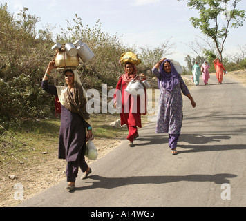 L'Inde Himachal Pradesh Taragarh femmes transportant des marchandises sur la tête en marchant le long road Banque D'Images