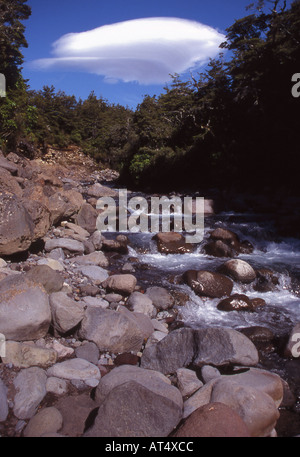 Le lit rocheux du ruisseau Whakapapanui et vague lointain de nuage dans Whakapapa Parc National de Tongariro, Nouvelle-Zélande Banque D'Images