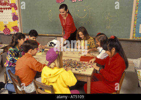 Groupe de quatrième ou cinquième année de travailler ensemble sur un puzzle Banque D'Images