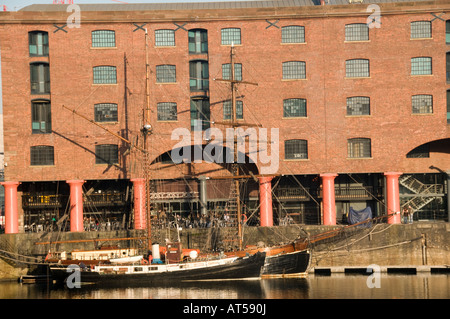 Albert Dock Liverpool - bateau amarré dans le dock par l'un des entrepôts convertis maintenant appartements bars et restaurants Banque D'Images