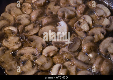 Pan plein de tranches de champignons à la poêle dans l'huile d'olive Banque D'Images