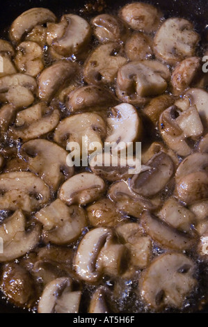 Pan plein de tranches de champignons à la poêle dans l'huile d'olive Banque D'Images