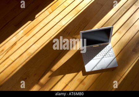 Apple ibook G4 ordinateur portable assis sur un vrai parquet dans l'après-midi soleil Banque D'Images