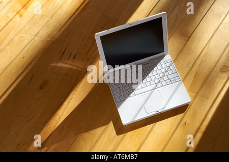 Apple ibook G4 ordinateur portable assis sur un vrai parquet dans l'après-midi soleil Banque D'Images