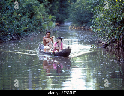 Une pirogue transporte une famille d'Indiens Pemon forêt tropicale à leur petit village le long de l'Orénoque Banque D'Images