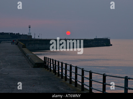 Coucher du soleil derrière le port et de la jetée, Maryport, Cumbria, Angleterre, Royaume-Uni Banque D'Images