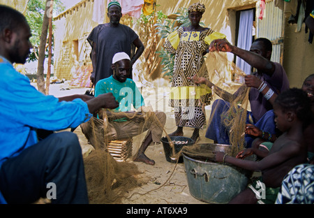 Les pêcheurs de la tribu Bozo démêlent les poissons d'un filet dans le village de Dagua Womina sur le fleuve Niger, Mali Banque D'Images