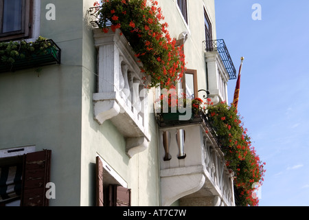 Drapeau, fleurs et balcons sur un bâtiment côté Canal blanc, Venise, Italie Banque D'Images