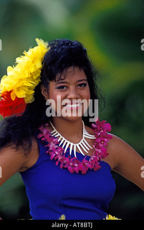 Belle jeune femme portant un Samoan purple orchid lei, collier de coquillages et vibrant jaune et rouge casque plumes smiles Banque D'Images