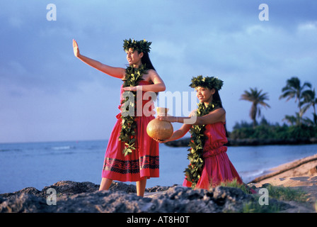 Deux jeunes femmes de la danse hula kahiko (ancienne) portant des leis maile avec l'UIP (gourd) près de ocean Banque D'Images