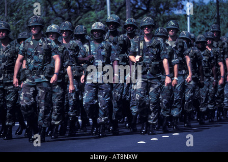 Close-up d'une unité militaire de jeunes soldats, des robes en combat treillis, casques et bottes, marchant vers le bas de l'Avenue Kalakaua Banque D'Images