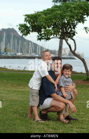 Portrait du père avec deux fils à magic island park avec Diamond Head et Ala Wai Yacht Harbour à l'arrière Banque D'Images