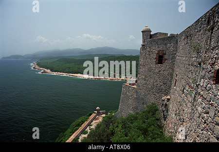 Groupe de touristes assis sur le bord d'un mur à la forteresse El Morro Santiago de Cuba Cuba Banque D'Images