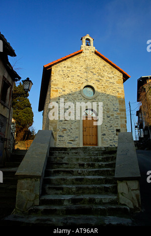 Petite chapelle restaurée en pierre avec petite porte en bois au-dessus de la rosette du beffroi Banque D'Images