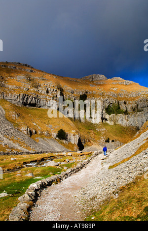 Marcher sous un ciel orageux à Gordale Scar Malhamdale Angleterre Yorkshire Dales Banque D'Images