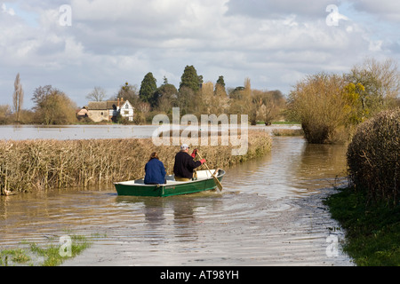 Résidents locaux voyageant en bateau dans une voie inondée près de la rivière Severn à Deerhurst, Gloucestershire Royaume-Uni en mars 2007 Banque D'Images