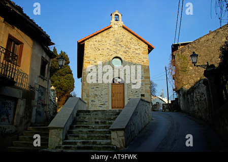 Petite chapelle restaurée en pierre avec petite porte en bois au-dessus de la rosette du beffroi Banque D'Images