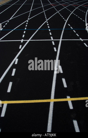 Signalisation des voies de circulation sur la surface noire d'une piste de course athlétique. Banque D'Images