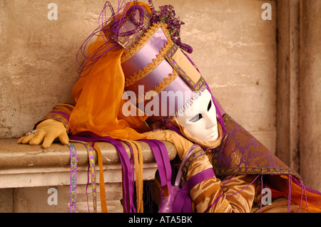 Carnaval de Venise Festival masque costume violet décoratif s'appuyant sur banc de marbre Banque D'Images