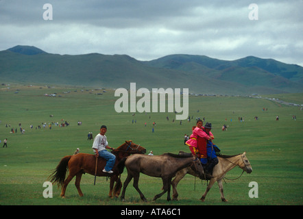 Les Mongols à cheval pendant la course de chevaux Festival Naadam à Oulan Bator Mongolie Banque D'Images