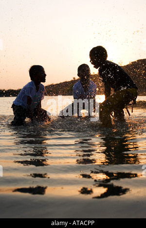Trois garçons indiens ayant une lutte de l'eau dans un lac en Inde Banque D'Images