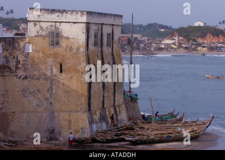 Bateaux de pêche échoués sont en dessous des murs du château d'Elmina, un esclave historique fort, au Ghana, Afrique de l'Ouest. Banque D'Images