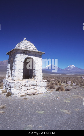 Adobe peint en blanc / cairn en brique de mudbrick près de Lagunas, volcans Payachatas en arrière-plan, Parc national de Sajama, Bolivie Banque D'Images