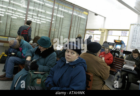 Les gens qui attendent sur leurs trains sur une gare ferroviaire à Cracovie, Pologne Banque D'Images