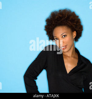 Tête et épaule studio portrait of smiling woman on blue background Banque D'Images