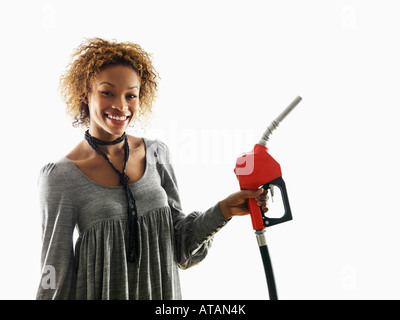 Portrait of pretty young woman smiling holding buse de la pompe à gaz sur fond blanc Banque D'Images